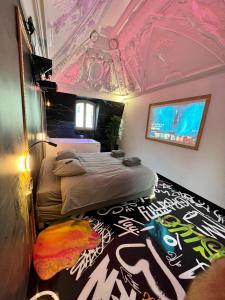 - une chambre avec un lit dans une pièce dotée d'un plafond dans l'établissement Capsule Art Déco - Jacuzzi - Netflix - Home Cinéma - Arcade de jeux & Nintendo switch - 2 chambres - Filet suspendu, à Valenciennes