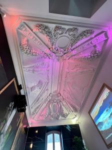un techo pintado en rosa y púrpura en Capsule Art Déco - Jacuzzi - Netflix - Home Cinéma - Arcade de jeux & Nintendo switch - 2 chambres - Filet suspendu, en Valenciennes