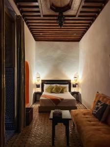 a bedroom with a bed and a couch at Riad Majorelle in Rabat
