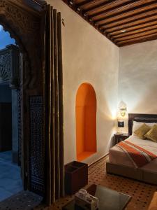 a bedroom with a bed and an open doorway at Riad Majorelle in Rabat