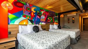 two beds in a room with a painting on the wall at Barrio Downtown Mexico City Hostel in Mexico City