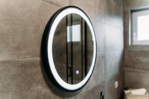 espejo de baño con marco negro en la pared en Apartman Star #1 en Vinkovci