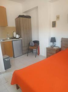 LivadiaにあるSpiros Apartmentsのキッチン(オレンジ色のベッド付)