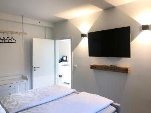 a bedroom with a flat screen tv on the wall at *Premium-Apartment im Spreewald* in Burg