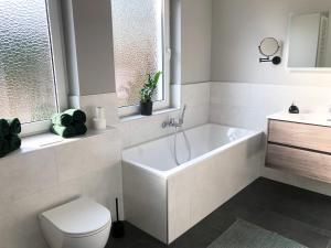 a bathroom with a tub and a toilet and a sink at *Premium-Apartment im Spreewald* in Burg +9 photos