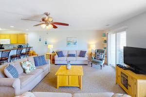 sala de estar con sofá y TV de pantalla plana en Seaside - Sand Dollar C-103, en Virginia Beach