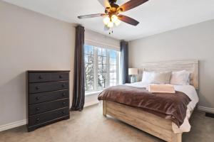 a bedroom with a bed and a ceiling fan at Waterfront Cottage on Georgian Bay w Hot Tub in Meaford