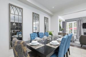 a dining room with a black table and blue chairs at Exceptional 3 BDRM Townhome - 4 Seasons Rental in Collingwood