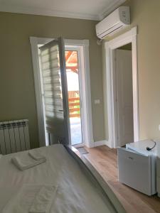 Schlafzimmer mit einem Bett und einer Tür zu einer Terrasse in der Unterkunft Absolut Residence Hateg in Haţeg