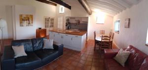 a living room with a couch and a table and a kitchen at 3 bedroom apartment overlooking river in Agde