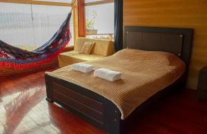 a bedroom with a bed with two towels on it at Cabaña en La Cocha - Janaxpacha in Los Alisales