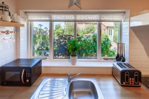 a kitchen with a sink and a window at St. Andrew's Prospect - Norfolk Cottage Agency in Norwich