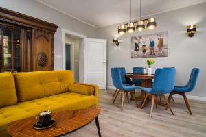 a living room with a yellow couch and a table at Apartament na Wspólnej in Elblag