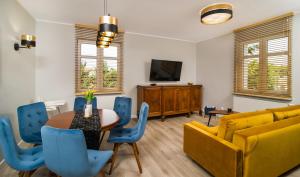 a living room with a table and a yellow couch at Apartament na Wspólnej in Elblag