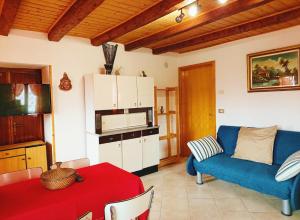 a living room with a blue couch and a microwave at Alloggio Matrimoniale vicino Asiago (Roana) in Roana