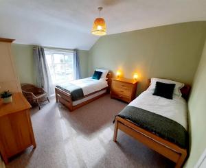 a small bedroom with two beds and a window at The Burnside Apartment in Fettercairn