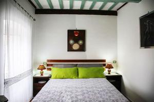 a bedroom with a bed with green pillows at B&B Natalia in Gualdo Tadino