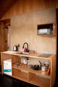 a small kitchen with a sink and a microwave at Villa Pancha del Lunarejo in Sierra de Lunarejo