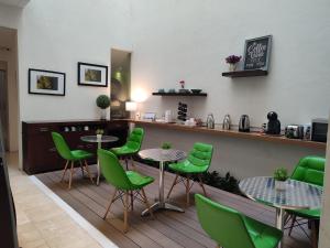 a restaurant with green chairs and tables and a counter at Lombardo Suites in Mexico City