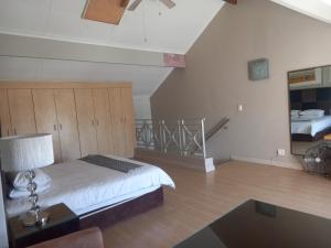 ein Schlafzimmer mit einem Bett und einer Treppe in einem Zimmer in der Unterkunft Mount Royal 31 - Large 1 bed with balcony in Johannesburg