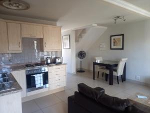 eine Küche und ein Esszimmer mit einem Tisch und einem Sofa in der Unterkunft Mount Royal 31 - Large 1 bed with balcony in Johannesburg
