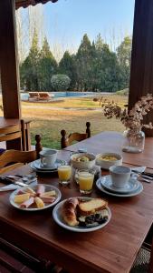 una mesa de madera con platos de comida. en La Bignonia Posada en Chacras de Coria