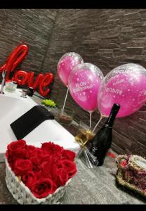 a table with a cake and balloons and a bottle of wine at Il Borghese Tourist House in Gela