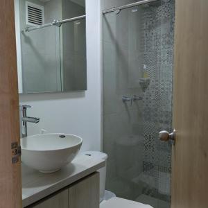 a bathroom with a sink and a glass shower at San Martin- Moderno y confortable apartaestudio sector rosales in Manizales
