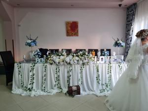 a bride is standing in front of a table with flowers at Pensiunea Vila Maria in Crăcăoani