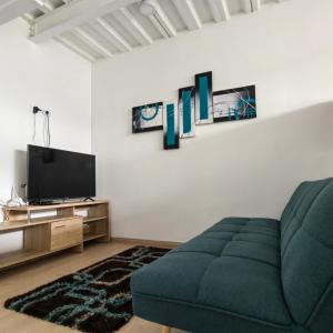 a living room with a couch and a tv at San Martin- Moderno y confortable apartaestudio sector rosales in Manizales