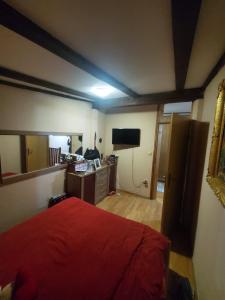 a bedroom with a red bed and a television at Samra in Sarajevo