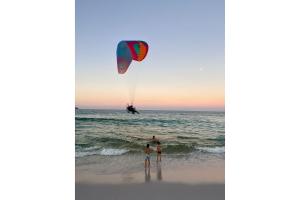 two people standing on the beach flying a kite at Casa Blanca Foguete 3 suítes Praia Lagoa SPA aquecido Piscina in Cabo Frio