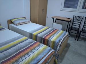 2 Betten in einem Zimmer mit einem Tisch und einem Stuhl in der Unterkunft Vila Grozdanoski in Konsko