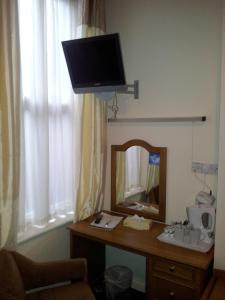 a desk with a tv and a chair in front of it at The County Hotel in Carlisle