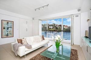 a living room with a couch and a glass table at BADEN - Absolute Water Front Sydney Harbour Studio in Sydney