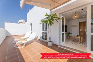 een balkon met witte stoelen en een potplant bij Apartments Urban Arrecife in Arrecife