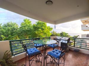 a balcony with a table and chairs on it at Beachfront Apartment In Joyuda With Pool And Basketball Court in Cabo Rojo