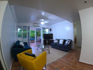 a living room with two couches and a tv at Beachfront Apartment In Joyuda With Pool And Basketball Court in Cabo Rojo