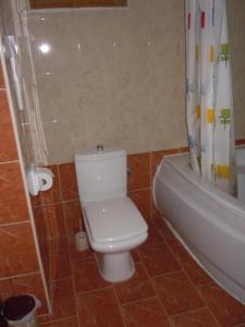 a bathroom with a toilet and a shower curtain at D-House in Birgu