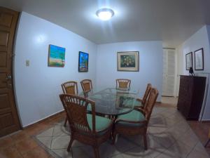 a dining room with a glass table and chairs at Beachfront Apartment In Joyuda With Pool And Basketball Court in Cabo Rojo