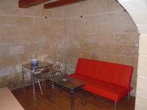 a red bench sitting next to a table and a chair at D-House in Birgu