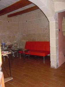 a red bench in a room with a table at D-House in Birgu