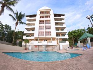 a building with a swimming pool in front of a building at Beachfront Apartment In Joyuda With Pool And Basketball Court in Cabo Rojo