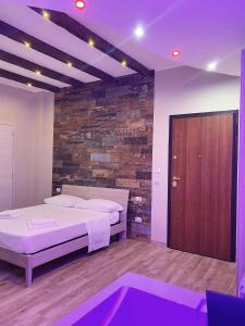 a bedroom with a bed and a brick wall at B&B New Paris & Suite in Taranto +16 photos