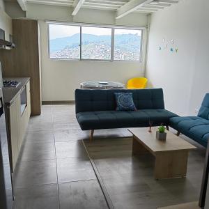 a living room with a blue couch and a table at San Martin- Moderno y confortable apartaestudio sector rosales in Manizales