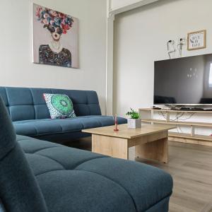 sala de estar con sofá azul y mesa en San Martin- Moderno y confortable apartaestudio sector rosales, en Manizales