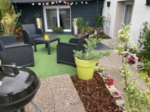 eine Terrasse mit Stühlen, einem Tisch und Pflanzen in der Unterkunft Sweet home, logement de tourisme in Étaples