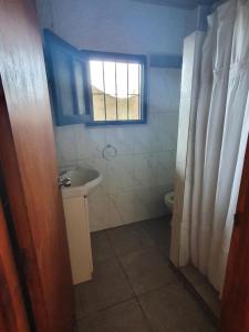 een kleine badkamer met een wastafel en een raam bij Ave Fénix in Aguas Dulces