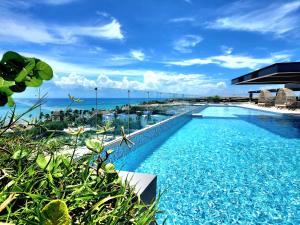a swimming pool with a view of the ocean at Singular Dream Beach Residences in Playa del Carmen