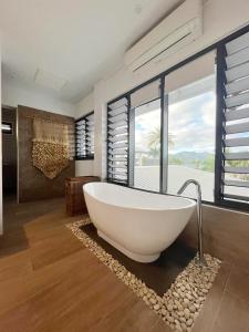 a bathroom with a white tub and a large window at Naisoso Island Villas - Fiji in Nadi